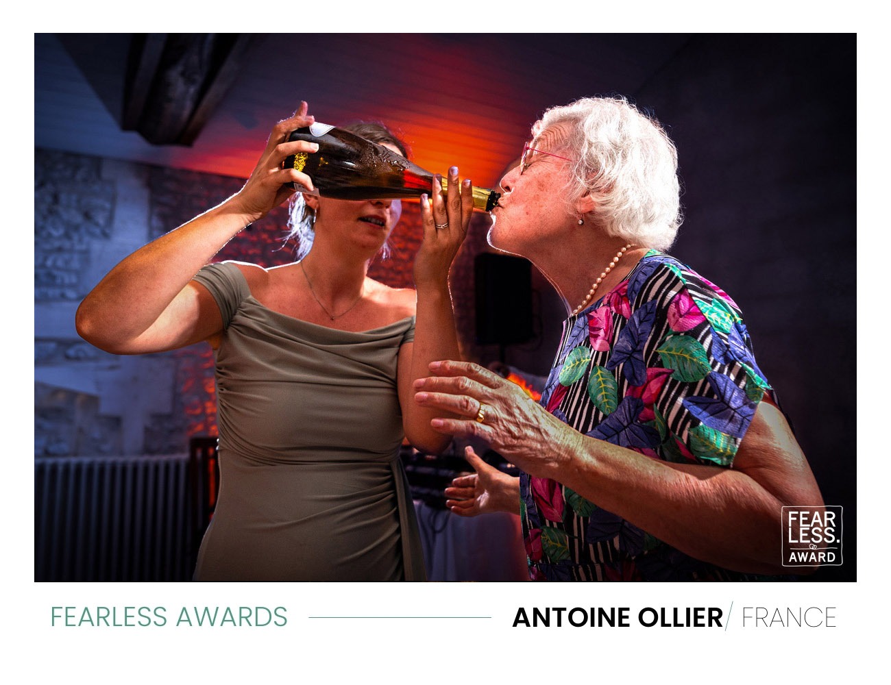 Photo gagnante du photographe de mariage en Charente Antoine OLLIER. Photo d'une mamie qui boit du champagne à un mariage