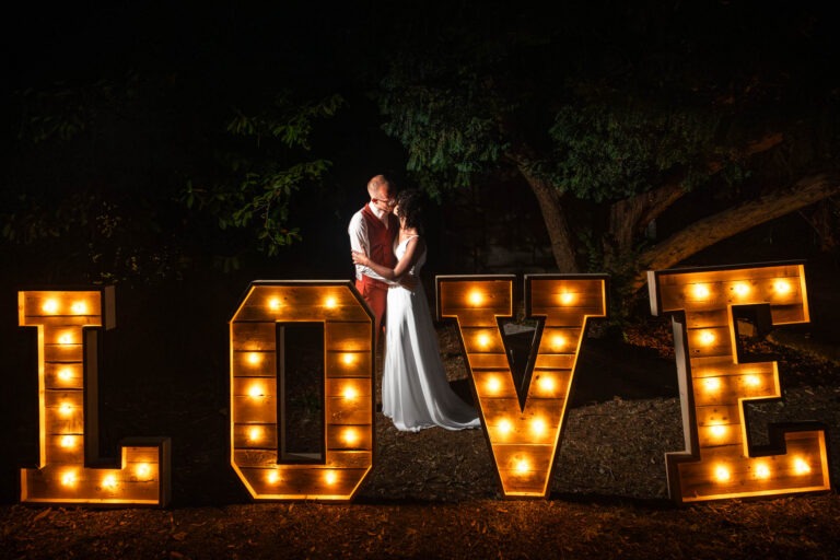 photographe mariage Charente - photo de couple devant un panneau lumineux love.