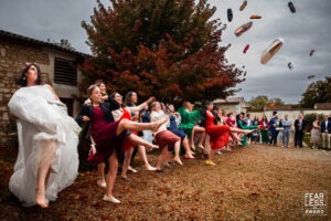 Mariée et les filles du mariage qui lancent leur savate lors d'un mariage en Charente - Photo de mariage réalisée par Antoine OLLIER - photographe mariage charente - photo récompensée par Fearless - photo au domaine de fontchaudière