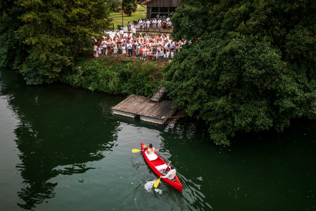Incroyable arrivées mariés en Canoë depuis le fleuve Charente à leur cérémonie laïque au quai des pontis à Cognac en Charente. Phot réalisée par le photographe de mariage Antoine OLLIER 
