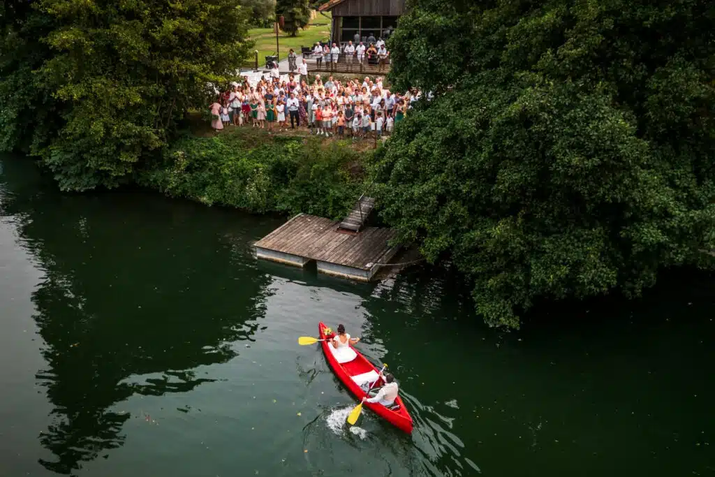 Incroyable arrivées mariés en Canoë depuis le fleuve Charente à leur cérémonie laïque au quai des pontis à Cognac en Charente. Phot réalisée par le photographe de mariage Antoine OLLIER 