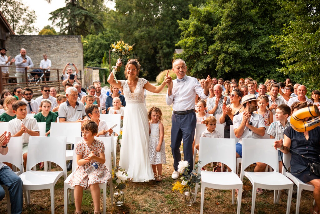Arrivée de la mariée avec son papa lors de la cérémonie laïque des mariés au domaine du Quai des Pontis à Cognac en Charente. Photo réalisée par le photographe de mariage en Charente Antoine OLLIER à Cognac (16)