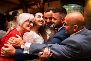 Scène de reportage lors d'un mariage en Charente. La mariée est enlacée par toute sa famille