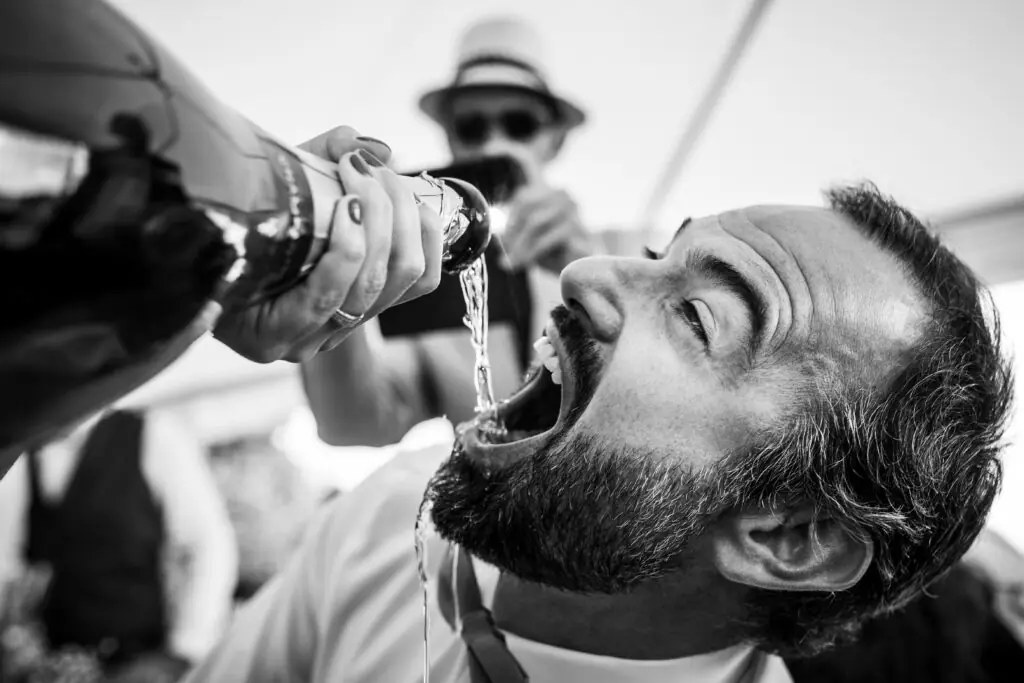 sc&egrave;ne incroyable d'un invit&eacute; du mariage qui boit du champagne qu'on lui verse dans la bouche. photo prise de tr&egrave;s pr&egrave;s sur un mariage en Charente