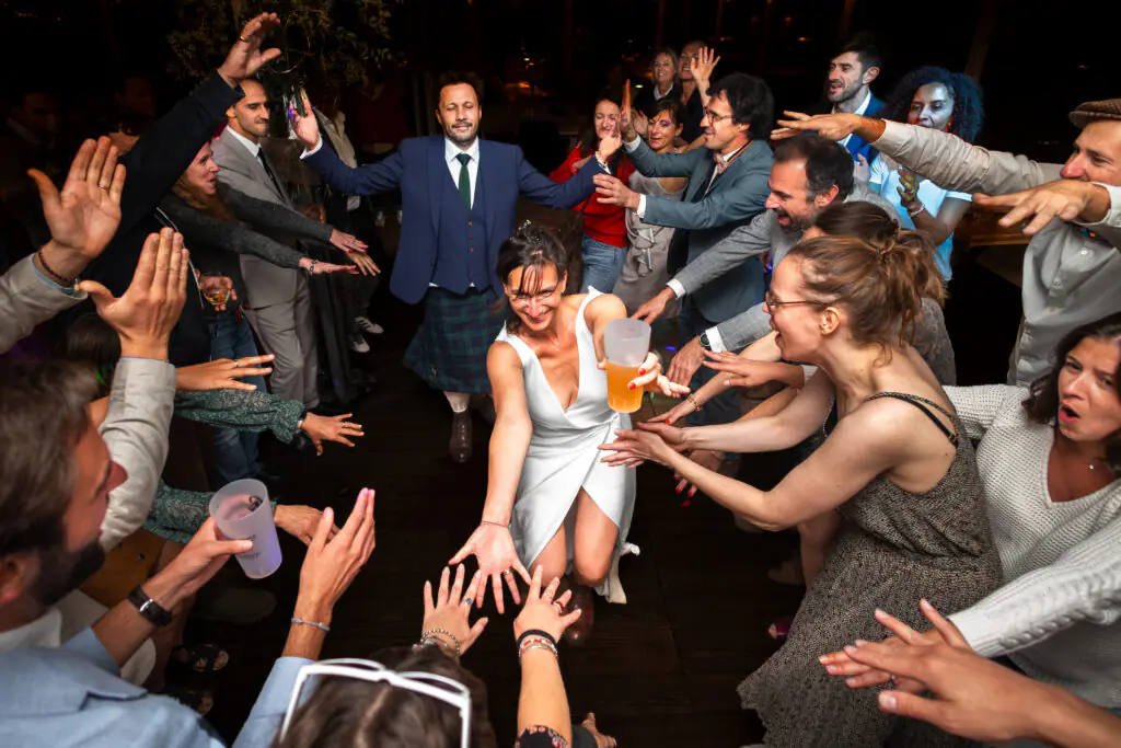 les mari&eacute;s arrivent au milieu de leurs invit&eacute;s qui les entourent sur leur mariage en charente, photo r&eacute;alis&eacute;e par Antoine OLLIER